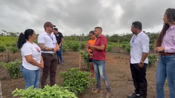 Imagem mostra 7 pessoas, 4 homens e 3 mulheres, de pé em uma área descampada