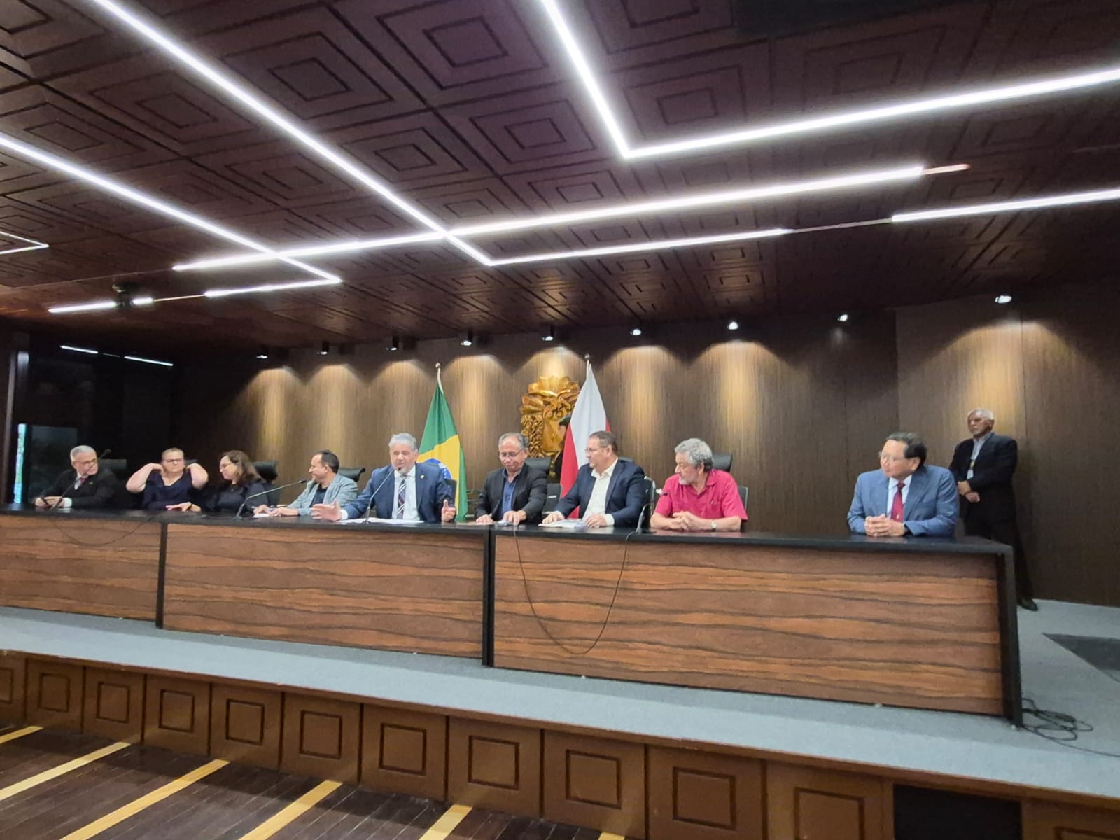 iMAGEM MOSTRA MESA DE AUDITÓRIO COM AUTORIDADES E CONVIDADES SENTADOS