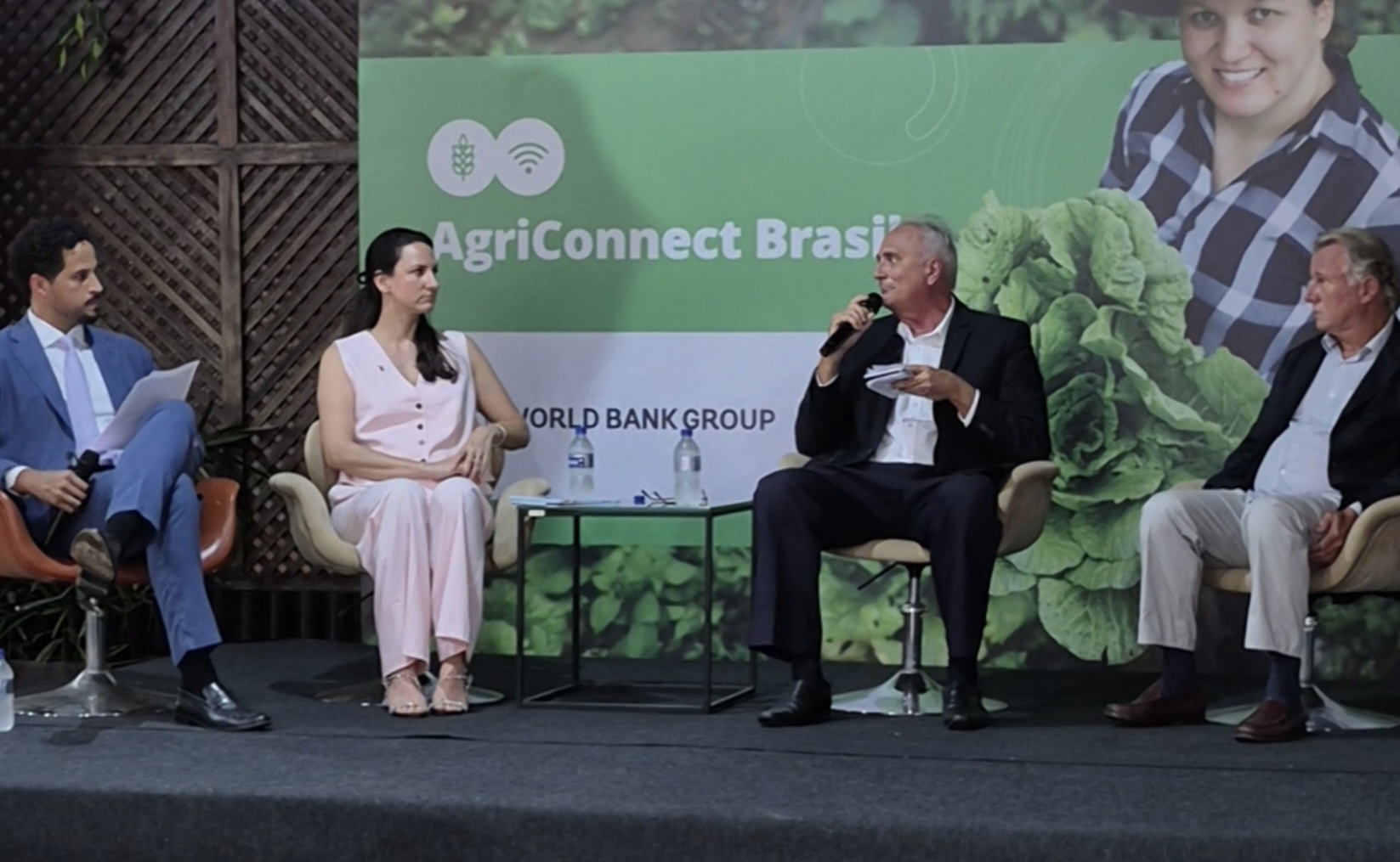 Imagem mostra quatro pessoas, uma mulher e três homens sentados, de idades e etnias diversas 