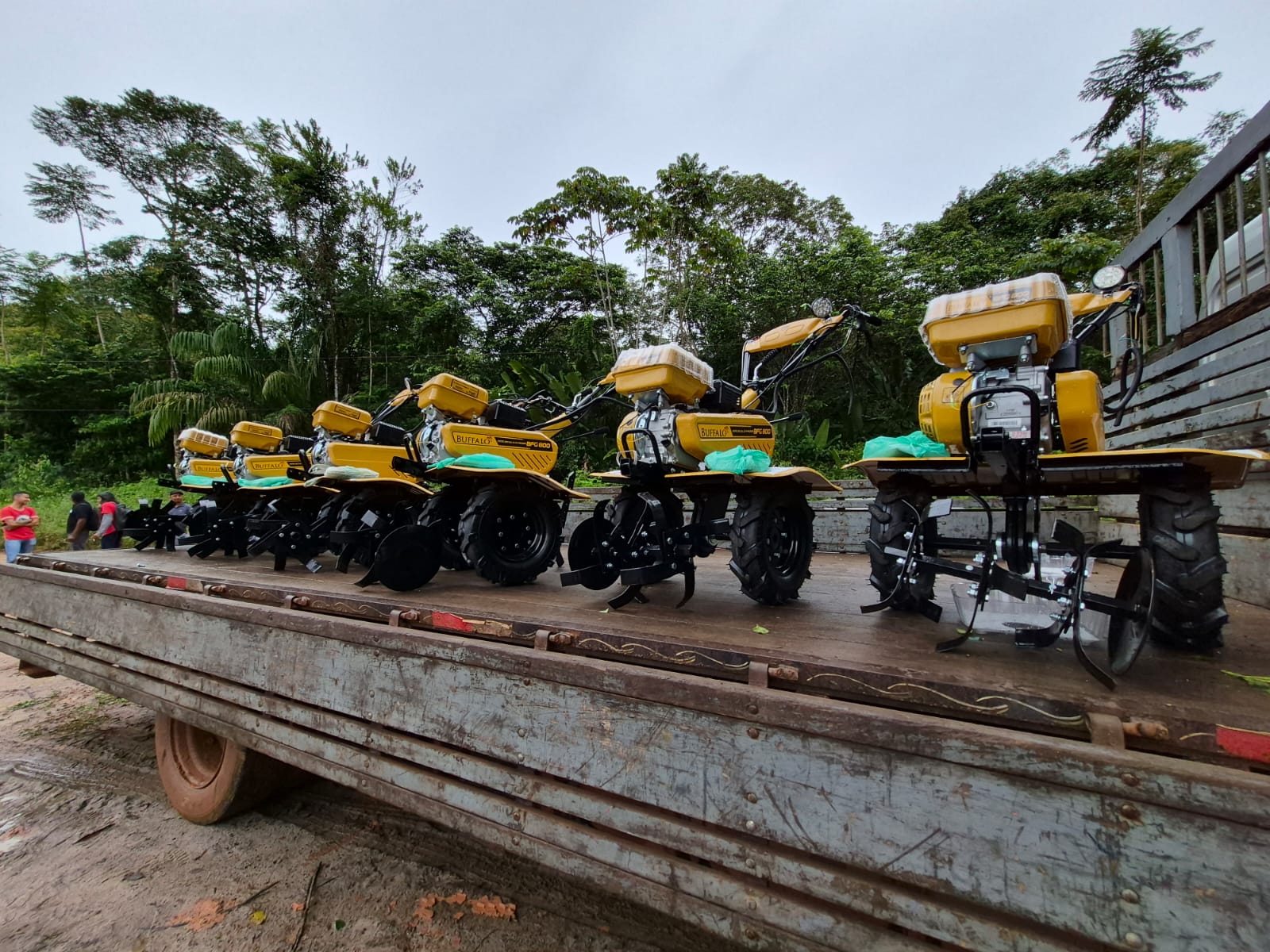 Imagem mostra seis motocultivadores enfileiradas na carroceria de caminhão