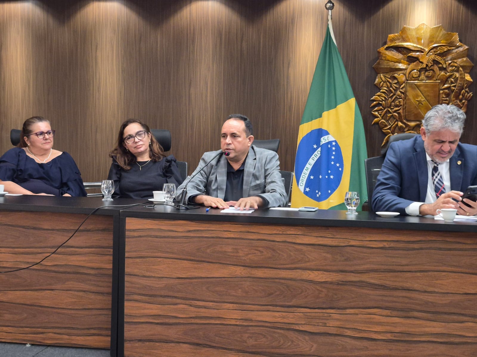 imagem mostra bancada em auditório com autoridades e convidados